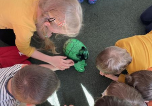 dzieci oglądają dinozaura w jaju